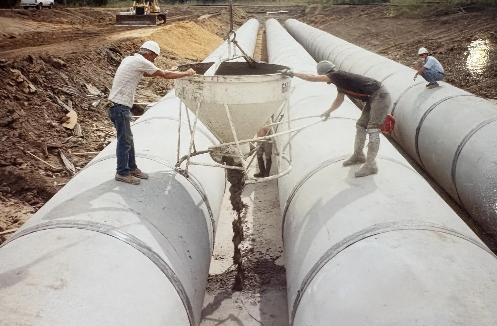 RKE crews grouting large-diameter concrete pipe in a shored trench