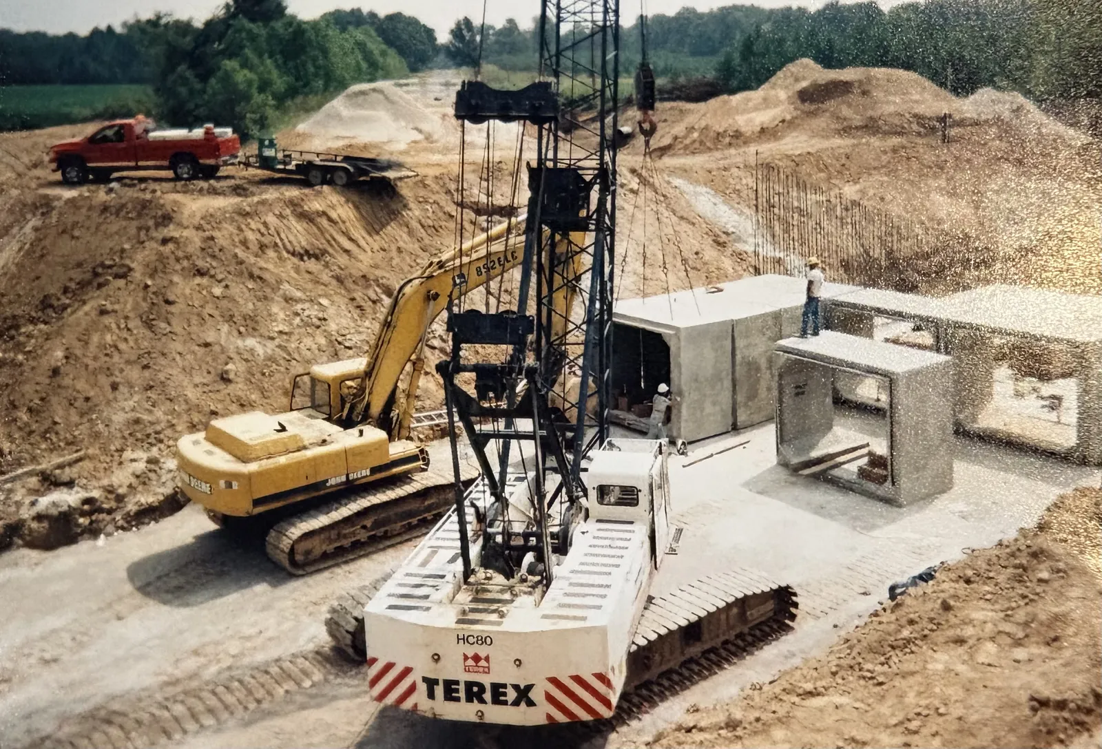 A Terex crane setting precast box culvert sections on a federal channel project