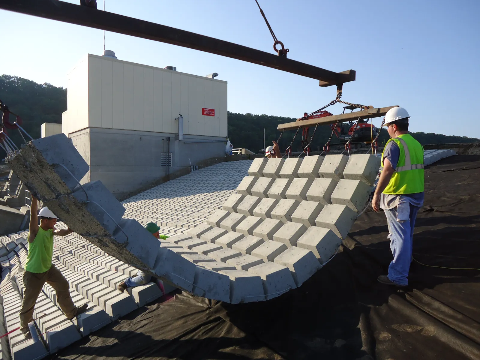An RKE crane setting an articulated concrete block mat at golden hour