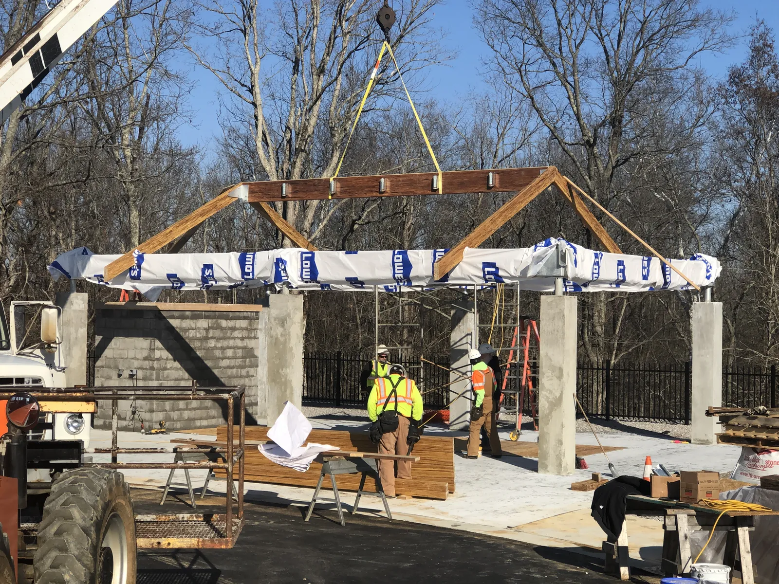 Crane setting a roof truss on a commercial structure